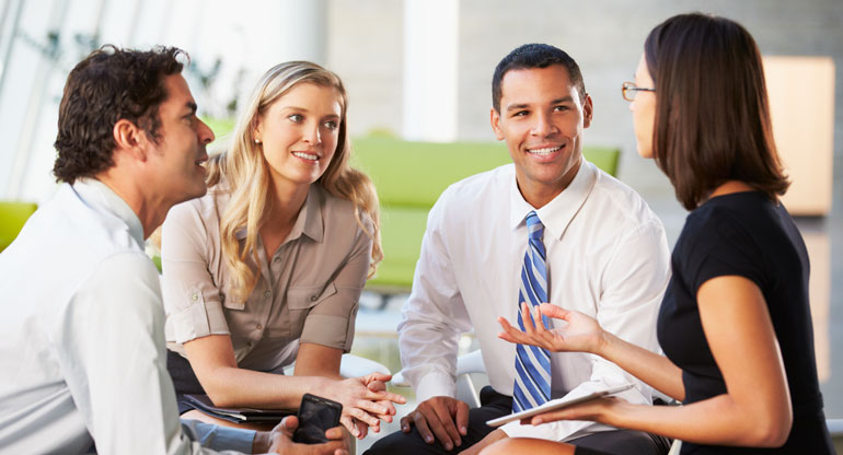 page_suppliers_body1 four people having a conversation in office