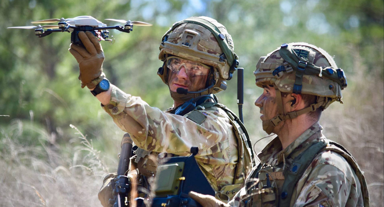 two soldiers testing a drone on the field