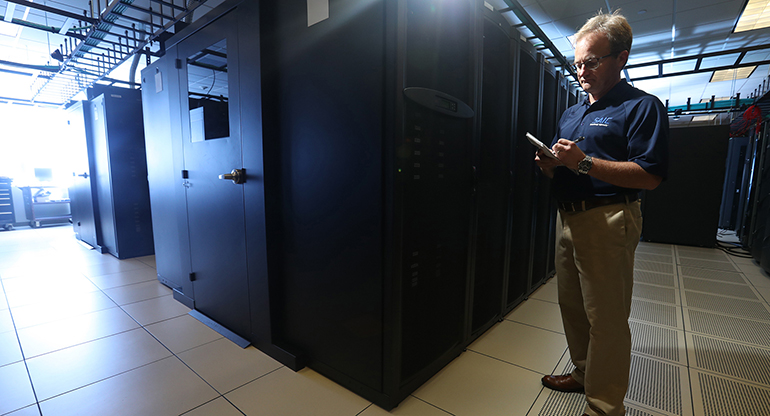 An SAIC employee runs diagnostics and checks in a server room. 
