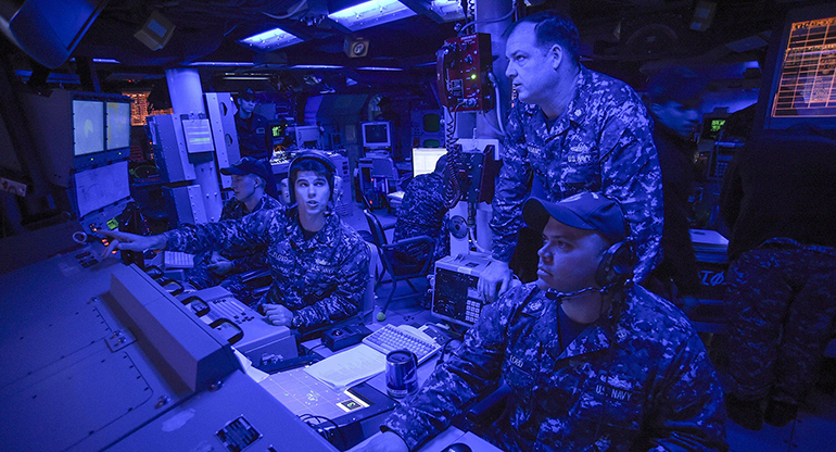 Service members can practice fleet synthetic training while embarked. Group shot of service members onboard the ship, performing an exercise.