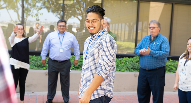 Man in the middle of a group outside 