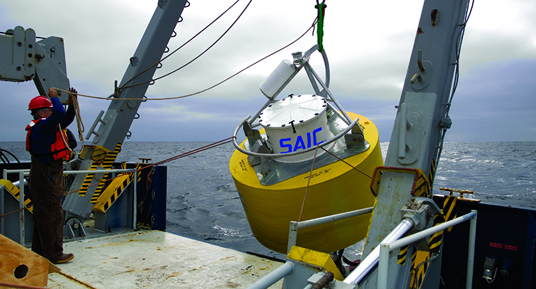 SAIC workers lower a tsunami buoy into the ocean.